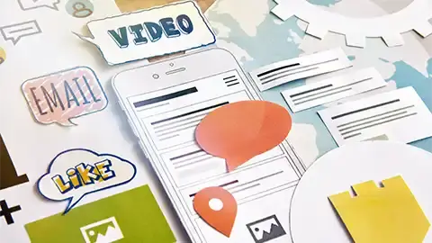 Paper cutouts and pages on a table with the words, video, email, and like displayed