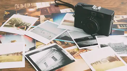 Photos and camera on a table top.